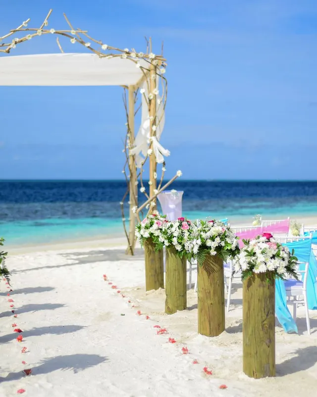 Hochzeitszeremonie am Strand mit Blumenschmuck